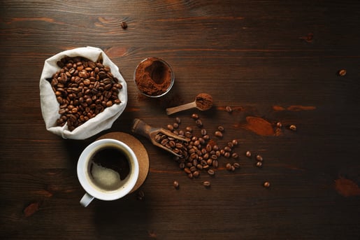 Ziarna kawy ziarniste na drewnianym stole i drewnianą łyżką Prima